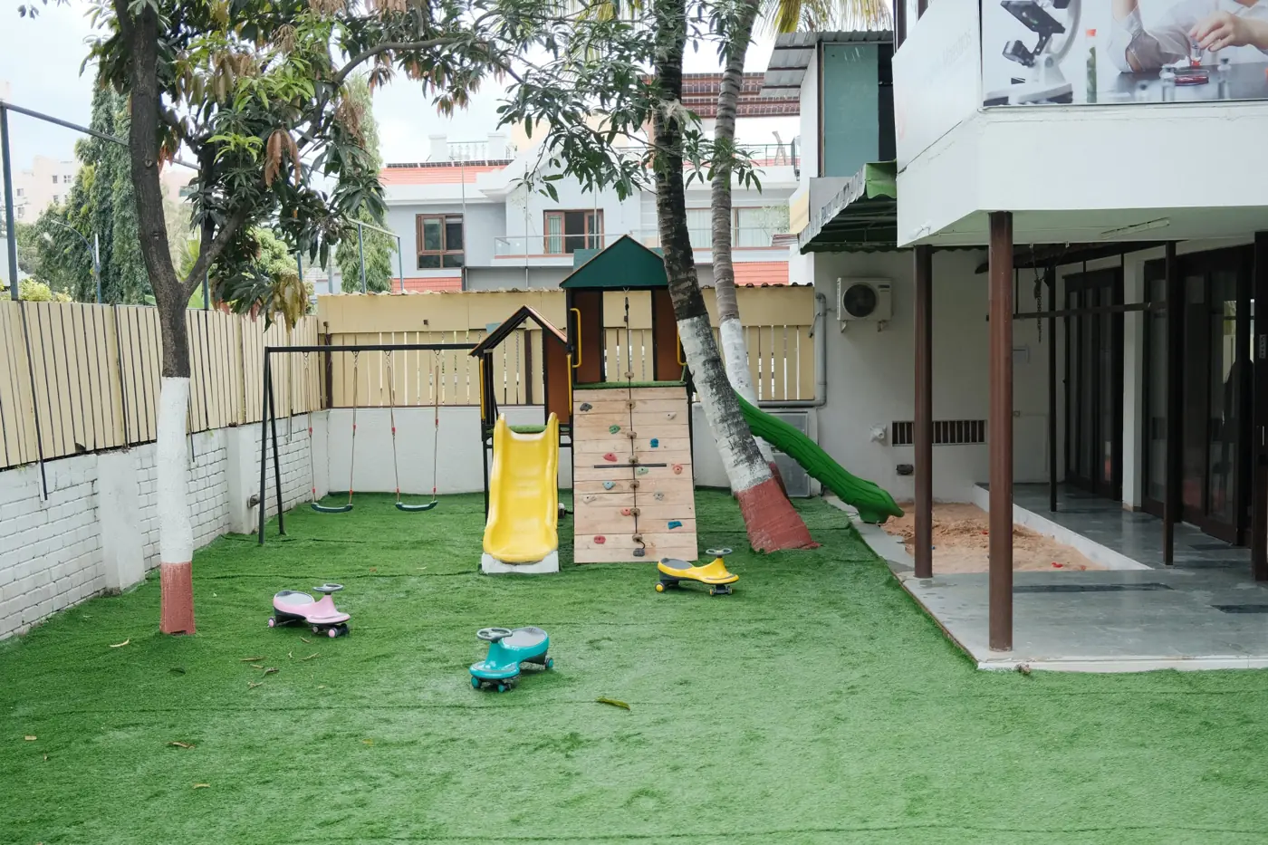 The garden playground with slides, swings, a climbing wall and sandpit